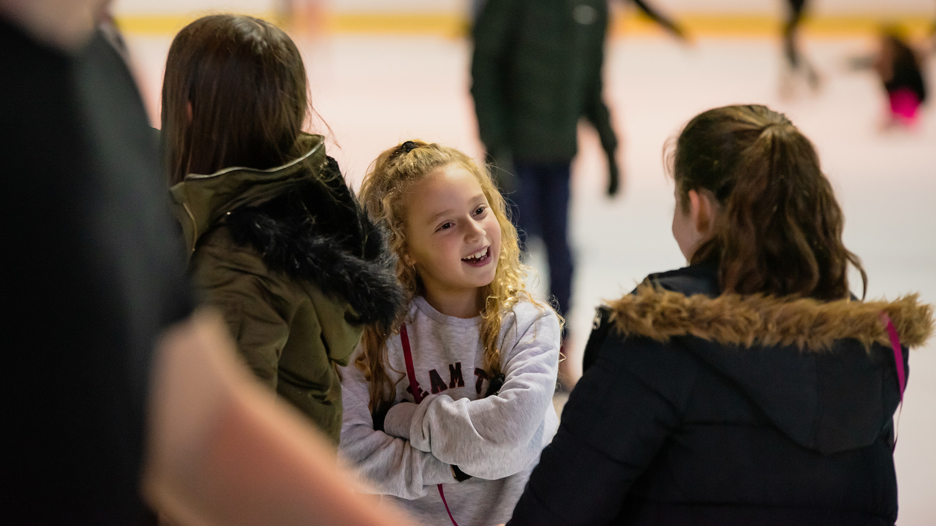 Young girls chatting and ice skating