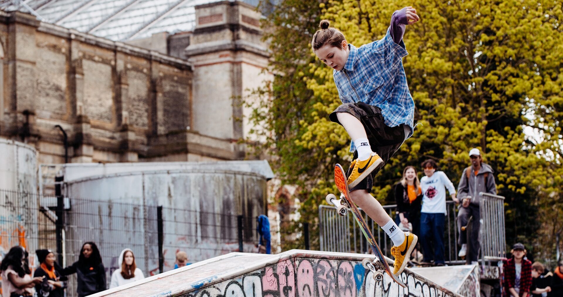 A skateboarder performs an impressive trick on a ramp at Skate Jam.